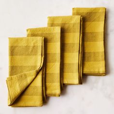 four yellow napkins sitting on top of a white counter