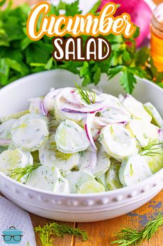 a white bowl filled with cucumber salad on top of a wooden table