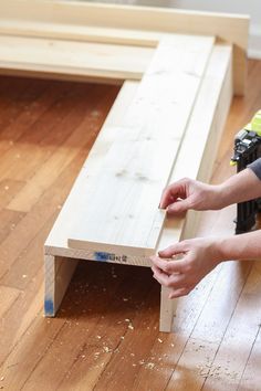 a person is working on a bench made out of plywood planks and wood