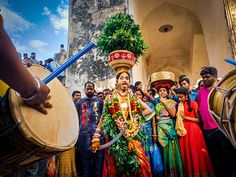 a group of people standing around each other with musical instruments in their hands and wearing costumes