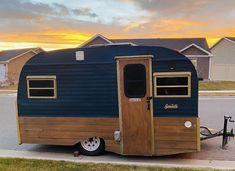 an old trailer is parked on the side of the road in front of some houses