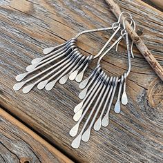 Silver Teardrop Boho Fan Earrings: These silver fan paddle earrings are the perfect mix of geometric & boho and will compliment any outfit! Graduated hammered paddles hang from a beautifully crafted teardrop focal point. These earrings are handcrafted from silver plated jewelers grade brass. They are approximately 2.75 inches in length and .62 inches at the widest portion. To view more of my original jewelry designs, visit: https://www.etsy.com/shop/TheBeadCounter Long Drop Metal Chandelier Earrings With Ear Wire, Long Drop Metal Chandelier Earrings, Unique Silver Dangle Teardrop Earrings, Unique Silver Teardrop Dangle Earrings, Metal Teardrop Pendant Earrings, Nickel Free Long Drop Teardrop Earrings, Nickel-free Long Drop Teardrop Earrings, Unique Teardrop Chandelier Earrings With Ear Wire, Unique Teardrop Chandelier Earrings