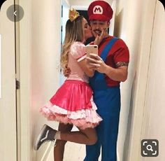 a man and woman dressed up as mario and princess peach are taking a selfie