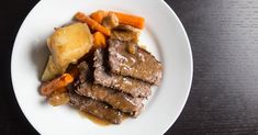 a white plate topped with meat, potatoes and carrots