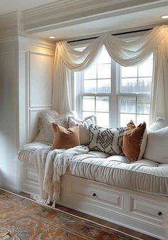 a white window seat with pillows on it