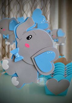 an elephant cutout sitting on top of a table next to blue plates and cups