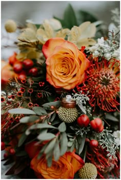 an arrangement of flowers and greenery is displayed in this image, including orange roses