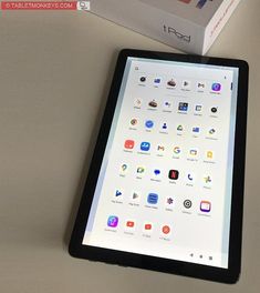 an ipad sitting on top of a table next to a box with app icons on it