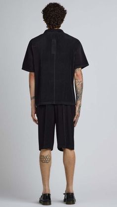 One size. fits xs-l  color: black  pleated material  quarter button up  short sleeve  100% polyester  dry clean only  by the nkc store    product measurements  chest: 132cm / 52in  length: 66.04cm / 26in    model is 185cm / 6'1" wearing size o/s Black Pleated Tops For Summer, Casual Short Sleeve Pleated Top, Black Pleated Summer Tops, Black Button-up Shirt For Streetwear, Black Unisex Short Sleeve T-shirt, Black Ring-spun Cotton Streetwear Shirt, Unisex Black Ring-spun Cotton T-shirt, Black Organic Cotton T-shirt For Streetwear, Easy Tiger