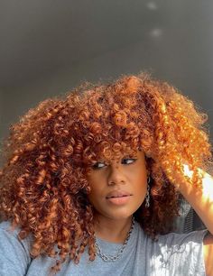 a close up of a person with an afro hair style and wearing a gray t - shirt