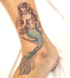 a woman's leg with a mermaid tattoo on it