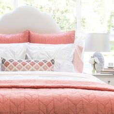 a bed with pink and white comforters in a bedroom