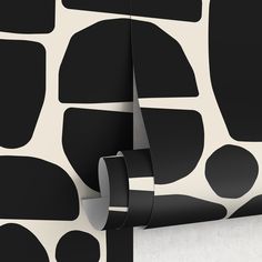 a black and white wallpaper with circles on it's side, next to a roll of tape