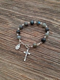 "Beautifully made Rosary bracelet! Beads are 8mm polished Labradorite stone, Cross is a 7/8\" silver St. Benedict crucifix, and mini medal is a 1/2\" mini medal with amazing details **Alternate Mini Medal Choices** 1. Holy Family/Holy Spirit 2. St Michael/Guardian Angel 3. Holy Eucharist and chalice *LOW STOCK* 4. St. Benedict medal 5. 5 way cross 6. Miraculous Mary medal 7. Sunburst cross *LOW STOCK* Each one of my rosary bracelets starts its life as a spool of wire and a handful of beads. It i Rosary Jewelry How To Make, One Decade Rosary Diy, Adjustable Silver Rosary Bracelet With Gemstone Beads, Silver Rosary Bracelet With 8mm Beads For Healing, Silver Rosary Bracelet With Natural Stones As Gift, Spiritual Silver Rosary Bracelet With Natural Stones, Silver Spiritual Rosary Bracelet With Gemstone Beads, Silver Rosary Bracelet With Gemstone Beads, Silver Rosary Bracelet With Gemstone Beads As Gift