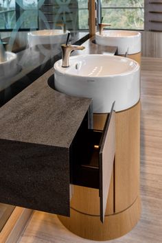 a bathroom with two sinks and mirrors on the wall next to each other in front of a window