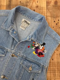 "Awesome 90's Mickey Mouse denim vest. Vest is in great & clean condition with little signs of previous wear. Perfectly worn in with naturally distressed denim character. Traditional Mickey Mouse embroidered emblems on front and back. Embroidery in great shape. Full button up front with adjustable buttons in back. Lightweight denim 100% cotton. See photos for details. Measurements (taken zipped-buttoned up and laid comfortably flat) x2 for total circumference (inches) Size Medium Shoulders 1 Mickey Mouse Jean Jacket, 90s Jean Jacket, Levis Jeans High Waisted, Mickey Mouse Jacket, Levis Mom Jeans, 90s Jean, 80s Clothing, Hip Hop Clothing, 90s Clothing