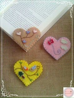 three heart shaped brooches sitting on top of a table next to an open book