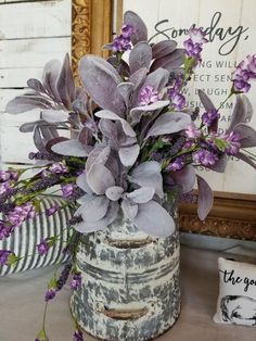 a vase with purple flowers in it sitting on a table