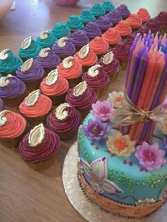 there are many cupcakes on the table and one is decorated with colorful icing