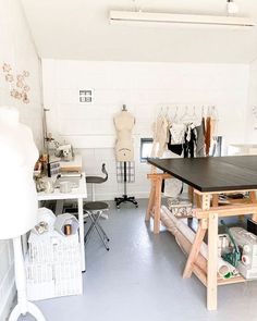 a room filled with lots of different types of clothing on mannequins and tables