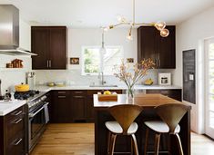 a kitchen with wooden cabinets and white counter tops next to an island in the middle