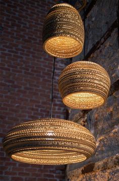 three circular lights hanging from a brick wall