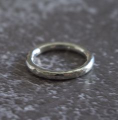 This is a classic band made in solid sterling silver. It has a hammered finish which is tactile and catches the light beautifully.  The ring is size O (centre) and it is constructed from round silver wire measuring approximately 2.6mm in diameter. Its approximate weight is 4.4g. The ring is hallmarked inside. I have also created some matching items which would look fabulous worn together as a set. https://www.etsy.com/uk/listing/266945656/silver-torque-bangle-hammered https://www.etsy.com/uk/lis Modern Sterling Silver Hammered Rings, Classic Sterling Silver Hammered Ring, Minimalist Silver Engraved Ring With Hammered Detail, Minimalist Silver Hammered Engraved Ring, Minimalist Hammered Silver Engraved Ring, White Gold Hammered Round Ring, Hammered White Gold Ring With Round Band, Silver Engraved Hammered Ring, Hammered Sterling Silver Round Band Ring