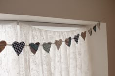 a curtain with hearts hanging from it's side in front of a white window