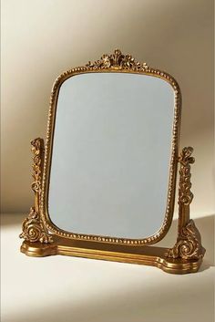 a mirror sitting on top of a table next to a white wall in the background