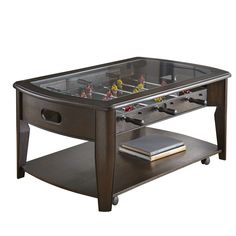 a coffee table with foosball on it and a book in the bottom drawer