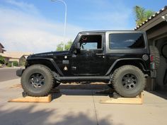 a black jeep parked in front of a garage