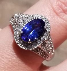 This is a Stunning 14K Tanzanite and Diamond Ring. I want you to know this is a Gem Quality Tanzanite with Exquisite Diamonds. That being said... This is a beautiful ring. It starts out with a 2.23 ctw Oval Tanzanite. You can see the blue and purple swirling around together to make a color that is hard to describe. It has .82 ctw. Of Bright, Shiny Diamonds that are VS clarity, G color. It just sparkles! This piece weighs 5.1 grams and it is a size 7. It is sizable by your local jeweler. I am pri Oval Tanzanite Halo Jewelry, Oval Tanzanite Jewelry With Halo Design, Gia Certified Tanzanite Oval Rings, Gia Certified Oval Tanzanite Ring, Oval Tanzanite Diamond Ring For Anniversary, Oval Tanzanite Rings Fine Jewelry, Gia Certified Oval Tanzanite Diamond Ring, Exquisite Oval Tanzanite Rings, Oval Tanzanite Diamond Ring With Accent Stones