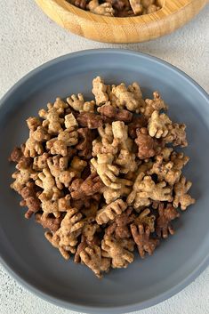 a blue plate topped with dog treats next to a wooden bowl