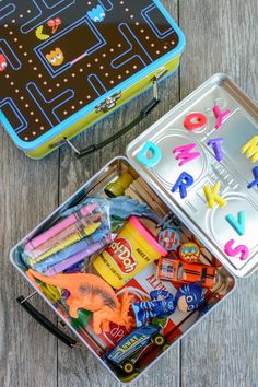 two tins filled with toys on top of a wooden table