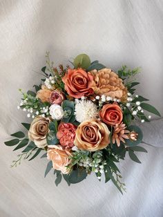 a bouquet of flowers on a white background with greenery and leaves in the center