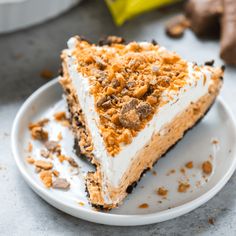 a piece of pie on a white plate with some chocolate chips and nuts around it