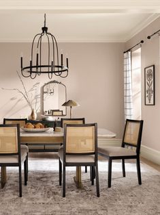 a dining room table with four chairs and a chandelier hanging from the ceiling