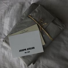 a piece of paper sitting on top of a bed next to a note with the name joseph atelierr