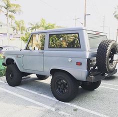 a gray truck parked in a parking lot next to palm trees and other vehicles on the street