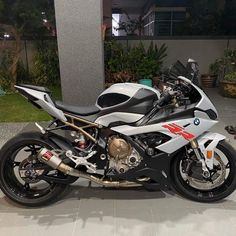 a white and black motorcycle parked in front of a building