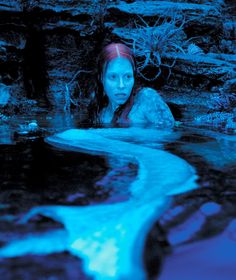 a woman is in the water with blue light