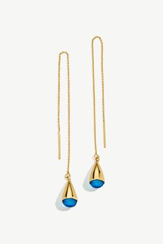 the gold and blue drop earrings are hanging from long chain, with a dangling ear hook