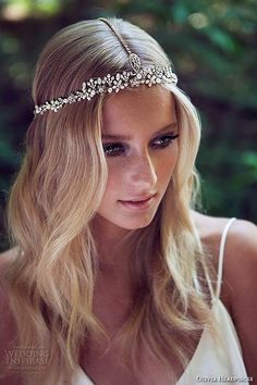 a woman with long blonde hair wearing a headband made out of pearls and beads