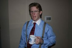 a man wearing suspenders and holding a coffee cup