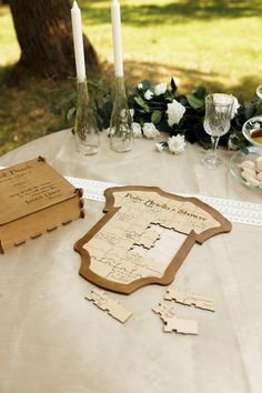 a table topped with lots of cut out pieces of paper next to candles and flowers