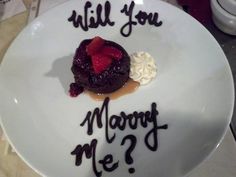 a white plate topped with a piece of cake and whipped cream