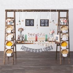 a wooden table topped with lots of food and drinks next to a white brick wall