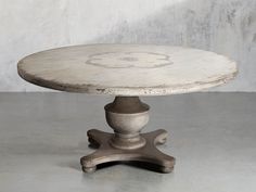 an old white table sitting on top of a cement floor