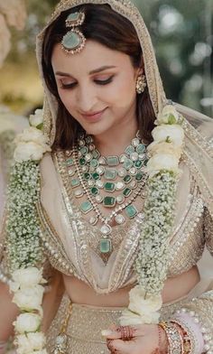 a woman wearing a wedding outfit and jewelry