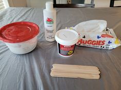 ingredients for making ice cream sitting on a bed next to a plastic container and wooden utensils